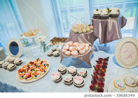 Delicious and tasty dessert table with cupcakes 39686349