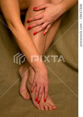 Beautiful female hands are on their feet. Beautiful female hands are on their feet. 39687886