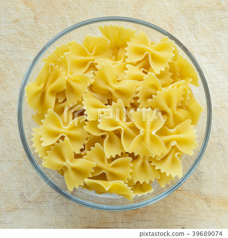 farfalle macaroni pasta in a glass bowl on a farfalle macaroni pasta in a glass bowl on a 39689074
