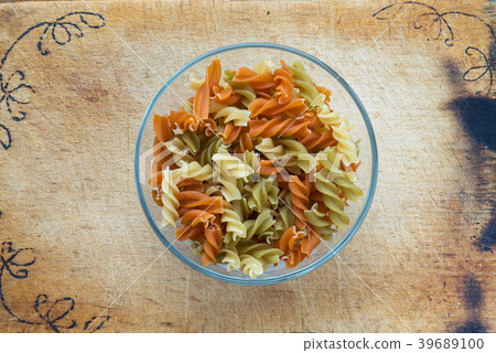 Multicolor spiral macaroni pasta in a glass bowl 39689100