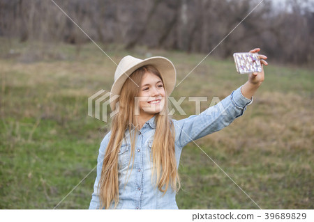 Pretty young girl making a selfie on her phone Pretty young girl making a selfie on her phone 39689829