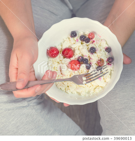 Full girl holding a plate of cottage cheese 39690013
