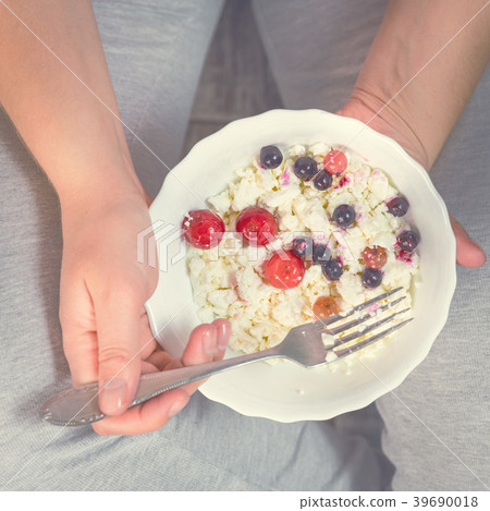 Full girl holding a plate of cottage cheese Full girl holding a plate of cottage cheese 39690018