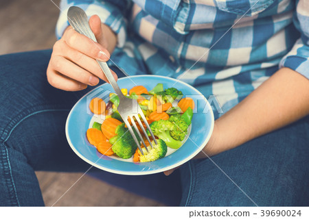 The girl holds a plate with vegetables The girl holds a plate with vegetables 39690024