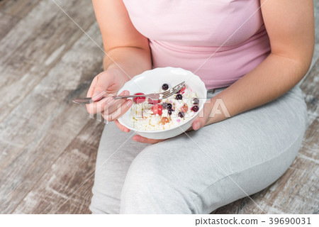 The girl is holding a plate of cottage cheese The girl is holding a plate of cottage cheese 39690031