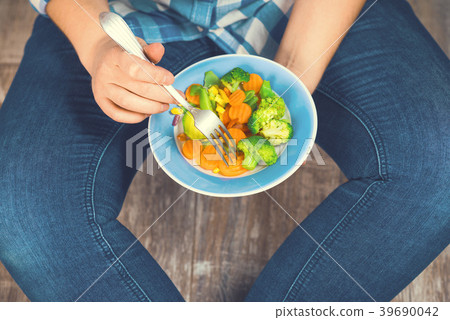 The girl holds a plate with vegetables 39690042