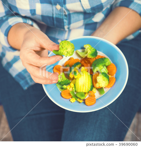 The girl holds a plate with vegetables 39690060