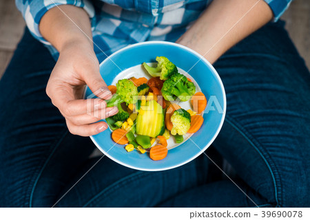 Girl with a plate of vegetables in hands 39690078