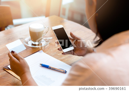 Businesswoman using cell phone with cup of coffee 39690161