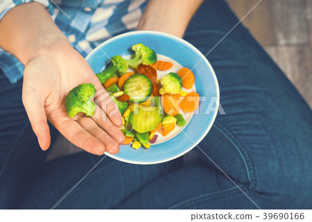 The girl holds a plate with vegetables 39690166