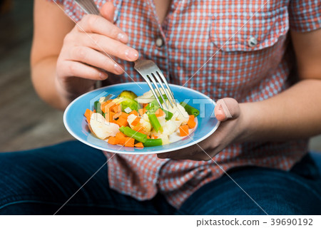 Girl with a plate of vegetables in hands 39690192