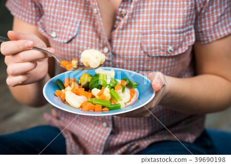 Girl with a plate of vegetables in hands 39690198