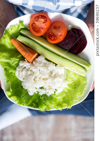 Girl with a plate of vegetables in hands 39690237