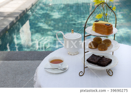 Afternoon tea with cup of tea and teapot and cake Afternoon tea with cup of tea and teapot and cake 39690275
