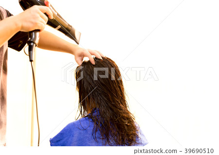 Man hairdresser using blower to dry customer hair Man hairdresser using blower to dry customer hair 39690510