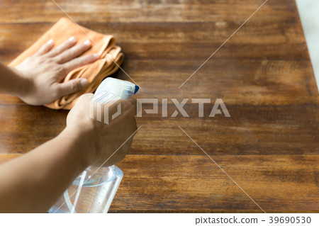 Waiter cleaning the table with Disinfectant Spray 39690530