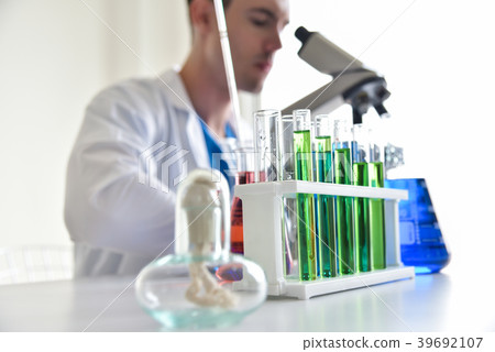 Young Man scientist looking through a microscope. 39692107
