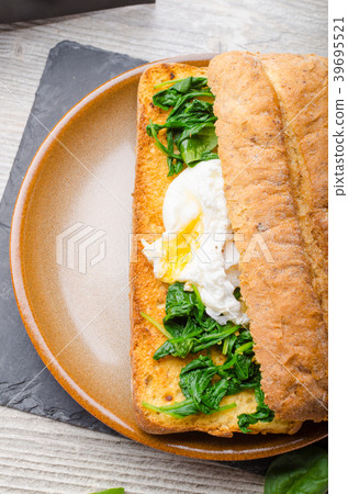 Toasted baguette with poached egg Toasted baguette with poached egg 39695521