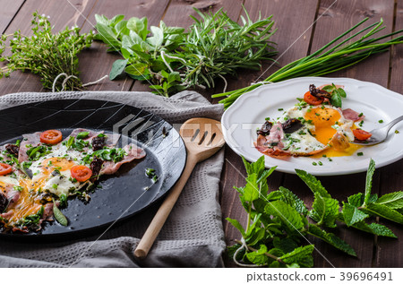 Fried eggs with ham and herbs 39696491