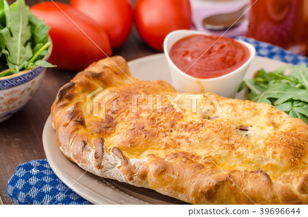 Calzone pizza stuffed with cheese and prosciutto 39696644