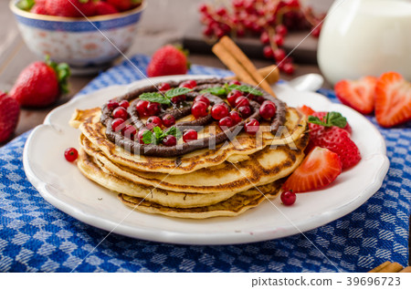 Cinnamon pancakes with chocolate sauce and berries 39696723
