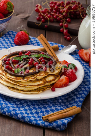 Cinnamon pancakes with chocolate sauce and berries 39696757