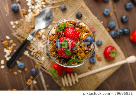 Yogurt with baked granola and berries in small glass Yogurt with baked granola and berries in small glass 39696831