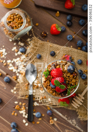 Yogurt with baked granola and berries in small glass Yogurt with baked granola and berries in small glass 39696832