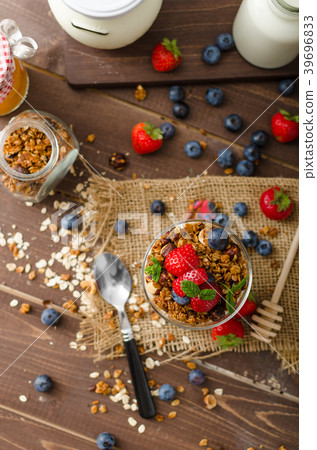 Yogurt with baked granola and berries in small glass Yogurt with baked granola and berries in small glass 39696833