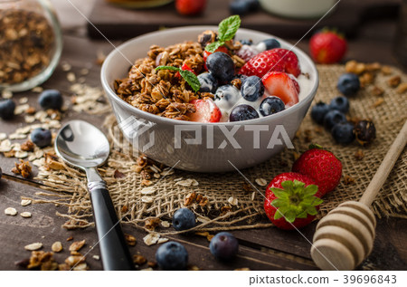 Yogurt with baked granola and berries in small bowl Yogurt with baked granola and berries in small bowl 39696843