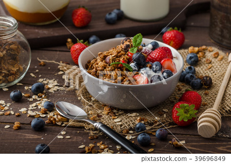 Yogurt with baked granola and berries in small bowl Yogurt with baked granola and berries in small bowl 39696849
