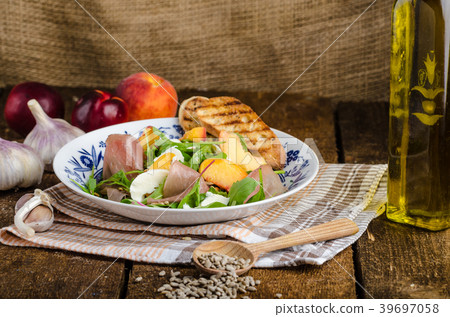 Rocket salad with prosciutto and fruit Rocket salad with prosciutto and fruit 39697058
