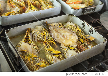 Hand holding forks inverted lobster roasting oil 39704169