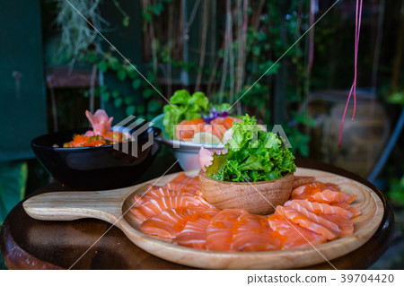 Salmon sashimi on wood plate with vegetables Salmon sashimi on wood plate with vegetables 39704420