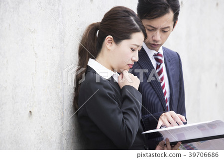 Upper body of businessman and businesswoman looking at materials Upper body of businessman and businesswoman looking at materials 39706686