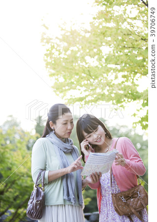 Parent and child making phone calls while looking at a map 39706749