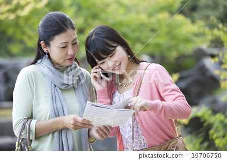 Parent and child making phone calls while looking at a map Parent and child making phone calls while looking at a map 39706750