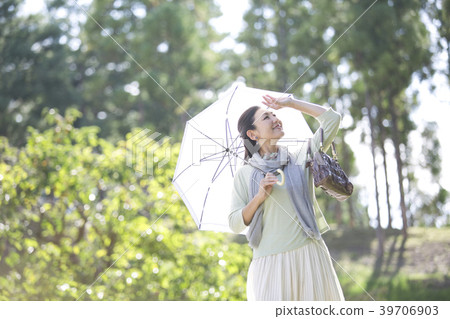Smiling middle-aged woman holding a parasol Smiling middle-aged woman holding a parasol 39706903