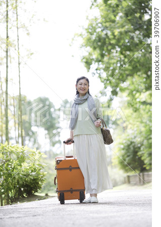 Smiling middle-aged woman with a suitcase 39706907