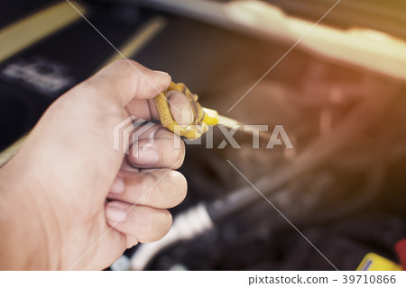 Hand of mechanic has checking oil engine level. Hand of mechanic has checking oil engine level. 39710866