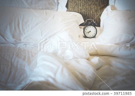 vintage black alarm clock at 8:00 am white bed. 39711985
