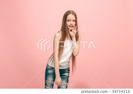 The young teen girl whispering a secret behind her The young teen girl whispering a secret behind her 39714318