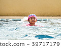 Asian girls are practicing swimming in the pool. 39717179