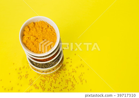 Various spices in bowls on yellow background. Copy 39717310