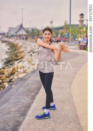 Sports concept. Beautiful girl is exercising on the beach with w 39717852