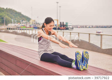 Sports concept. Beautiful girl is exercising on the beach with w 39717922