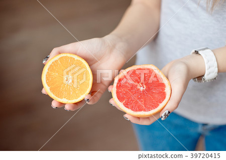 Orange and grapefruit in human's hands. Orange and grapefruit in human's hands. 39720415