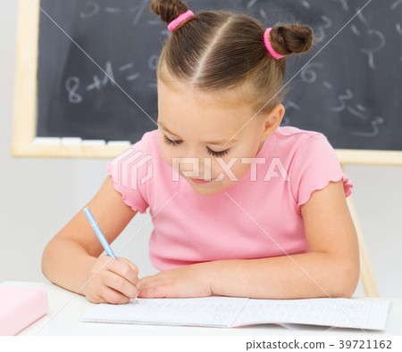 Little girl is writing using a pen Little girl is writing using a pen 39721162