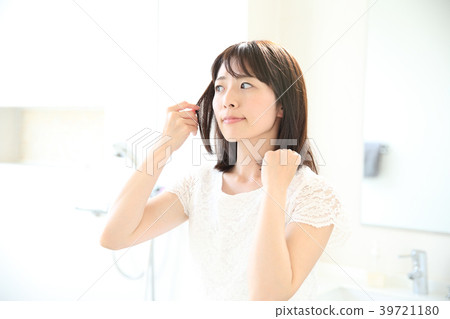 A woman preparing her hair A woman preparing her hair 39721180