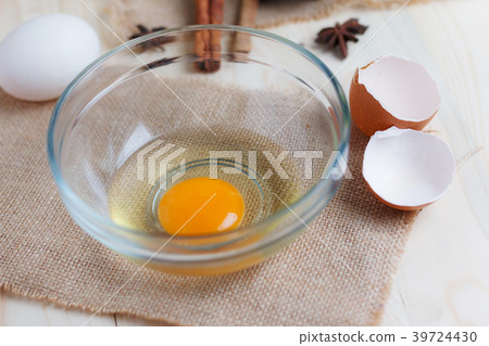 Egg on clear glass bowl over wooden cut board 39724430